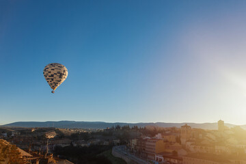 Hot air balloon flying over the old city of segovia, spain