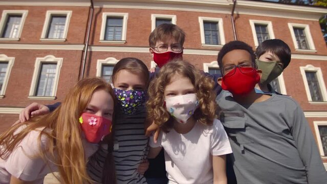 School-age children in medical mask looking at camera. Realtime