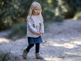 Little girl walking thoughtfully in the woods