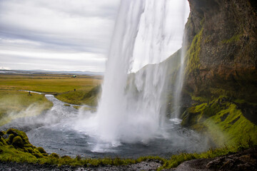 Seljalandsfoss Iceland is a stunning waterfall that allows visitors to walk behind the cascading water.