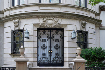 Entrance to elegant baroque style apartment building or townhouse, with decorative and protective iron grill on windows