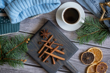 Christmas tree made of cinnamon sticks and black coffee, sweater, jeans on a wooden table.