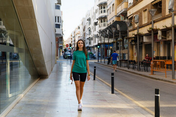 Sporty stylish girl goes in for sports and walks in the city