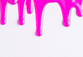 Pink liquid drops of paint color flow down on white canvas. Abstract art. Red paint dripping on the white wall with copy space.