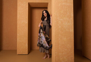 Fototapeta premium A woman wearing dress in a beige sandstone room. warm and cozy atmosphere.