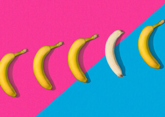 Row of bananas on pink and teal colour background