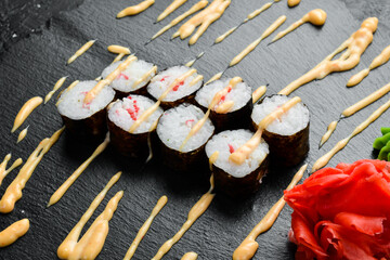 Classic maki rolls. On a black stone background. Top view.