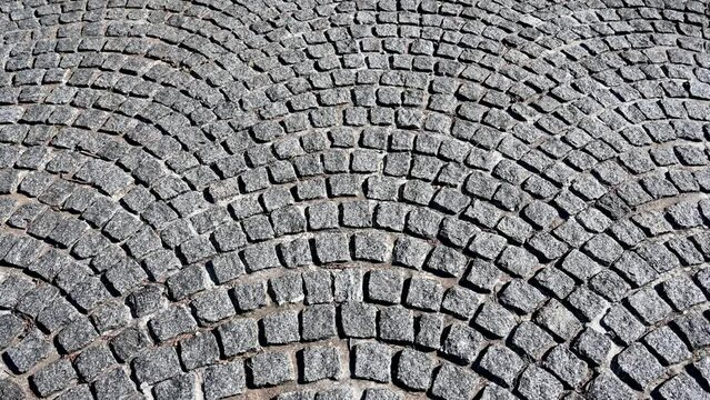 Cobblestone pattern on the road. Cobblestone texture on the street, close up. Brick floor tiles.