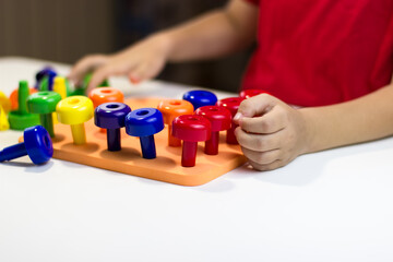 Children's pens playing plastic mushrooms on a white background