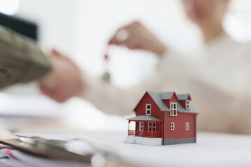 A plastic model of a red house on the table, closeup