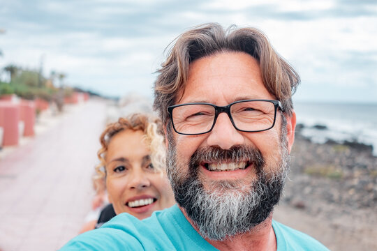 Portrait Of Handsome Happy Couple Of People, Bearded Middle Aged Man And Curly Woman In Friendship And Relationship Looking At Camera In Outdoor Smiling