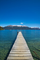 Long pier towards the lake of Villa La Angostura in Patagonia. Mountains in the background
