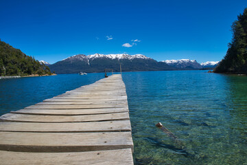 Long pier seen from below towards the lake of Villa La Angostura in Patagonia. Mountains in the background