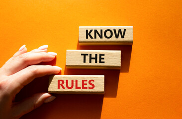 Know the rules symbol. Wooden blocks with words Know the rules. Beautiful orange background. Businessman hand. Business and Know the rules concept. Copy space.