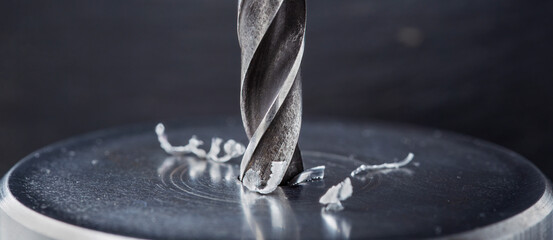 metal drill bit make holes in steel billet on industrial drilling machine. Metal work industry....