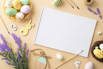 Easter inspiration concept. Top view photo of sketchbook brushes colorful easter eggs in bowl wooden decorative bunnies twine nest and lavender flowers on isolated beige background with copyspace