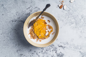 Fototapeta na wymiar Yogurt granola bowls with orange fruits, top view. Healthy vegetarian breakfast meal
