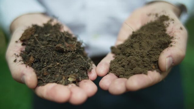 Environmental soil scientist holds good and bad soil in two hands to compare