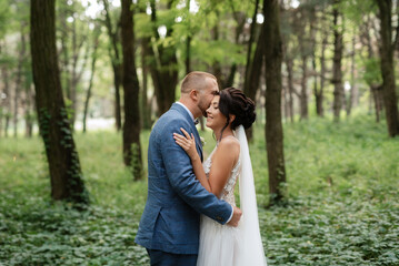 wedding walk of the bride and groom in the deciduous forest in summer