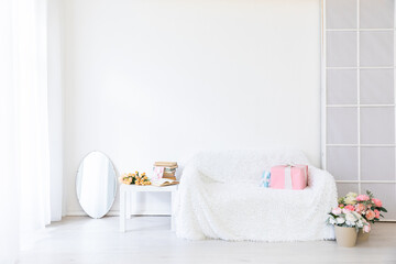 white sofa with gifts coffee table with flowers in bright interior room