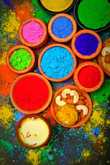 top view of colorful traditional holi powder in bowls isolated on dark background.Space for text . happy holi.Concept Indian color festival called Holi