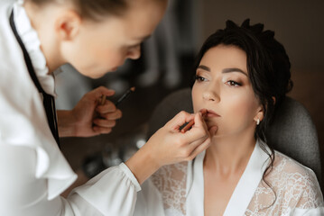 make-up artist makes a wedding look to the bride with makeup