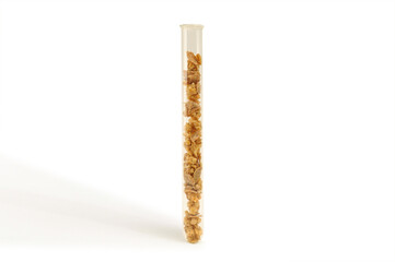 Healthy muesli in a test tube on a white background