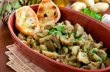 Vassoio con delizioso stufato di carciofi e patate, cibo vegetariano 