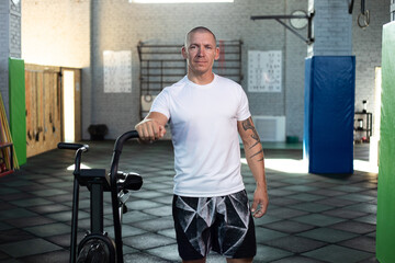 Fototapeta na wymiar Man in white t-shirts in a crossfit gym. Mock-up.