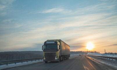 Truck on a suburban highway at sunset in spring. Logistics, cargo transportation.