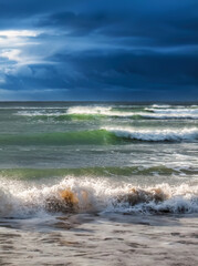 Rough surf rolling in under dark, heavy storm clouds