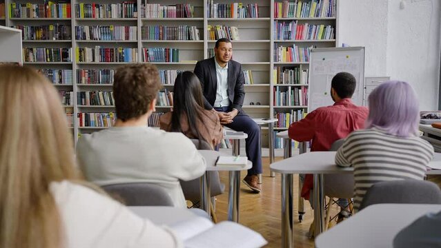 Young African American professor teaching a lecture at library campus of a high school establishment