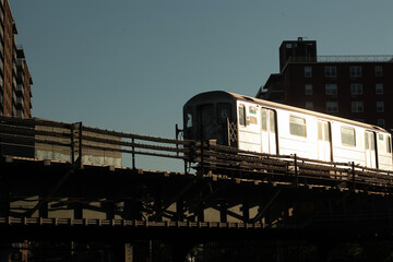 Bronx New York silver elevated subway 6 train reflecting the early morning sunlight - obrazy, fototapety, plakaty