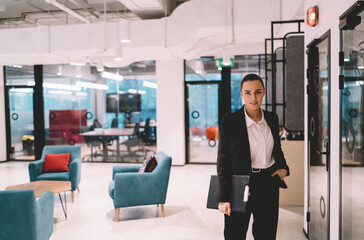 Positive businesswoman with folder in creative office