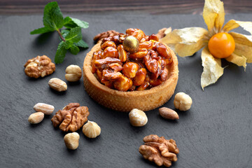 baked dessert with caramelized nuts, on a black background