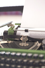 Vintage green typewriter machine with a sheet of paper and generic text typed, closeup photo