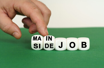 On a green surface are white cubes with the inscription - MAIN JOB or SIDE JOB