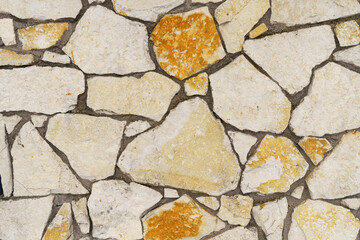 White - yellow texture of a stone wall with shades of different colors.