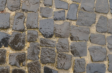 Wet black pavement pavement after rain. Textures and paving stones