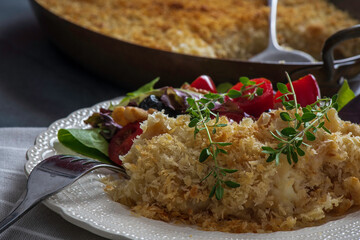 Salt cod brandade garnished with thyme. Salt cod is blended with potatoes, milk, garlic, and olive oil, then baked in a casserole or au gratin pan.