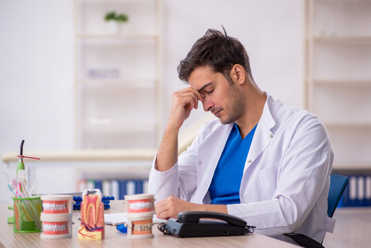 Young male dentist working in the clinic