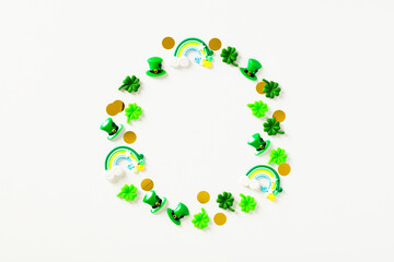 St Particks Day composition. Circle of festive decorations, leprechauns hats, confetti, rainbows on white background. Flat lay, top view.