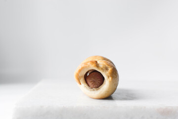 Sausage roll on a marble tray, twisted sausage roll on a marble tray, Large pigs in a blanket snack