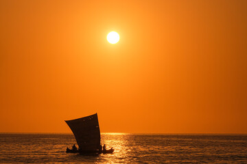 Malagasy boat sailing under the sunset in madagascar