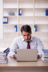 Fototapeta premium Young male employee and too much work in the office
