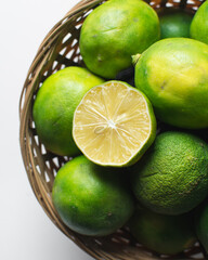 Top view of organic green limes in  a basket, Top view of sliced green lime
