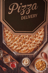 Brazilian pizza with tomato sauce, mozzarella, corn, catupiry and oregano  in a delivery box (Pizza de milho especial) - Top view.