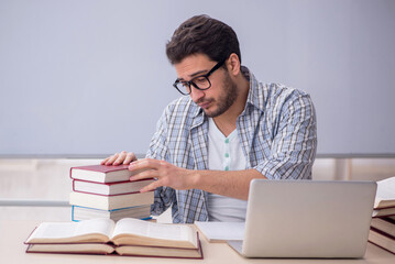 Young male student sitting in the classroom