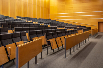 Naklejka premium Interior of big conference hall full of gray folding chairs and wooden walls
