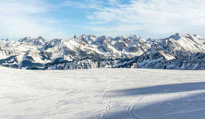Man is snowshoe hiking with amazing view to alpine winter mountains landscape. Ifersguntalpe, Vorarlberg, Austria.